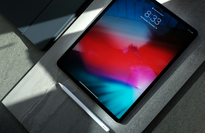 Tablet with a colourful screen lying on a grey desk